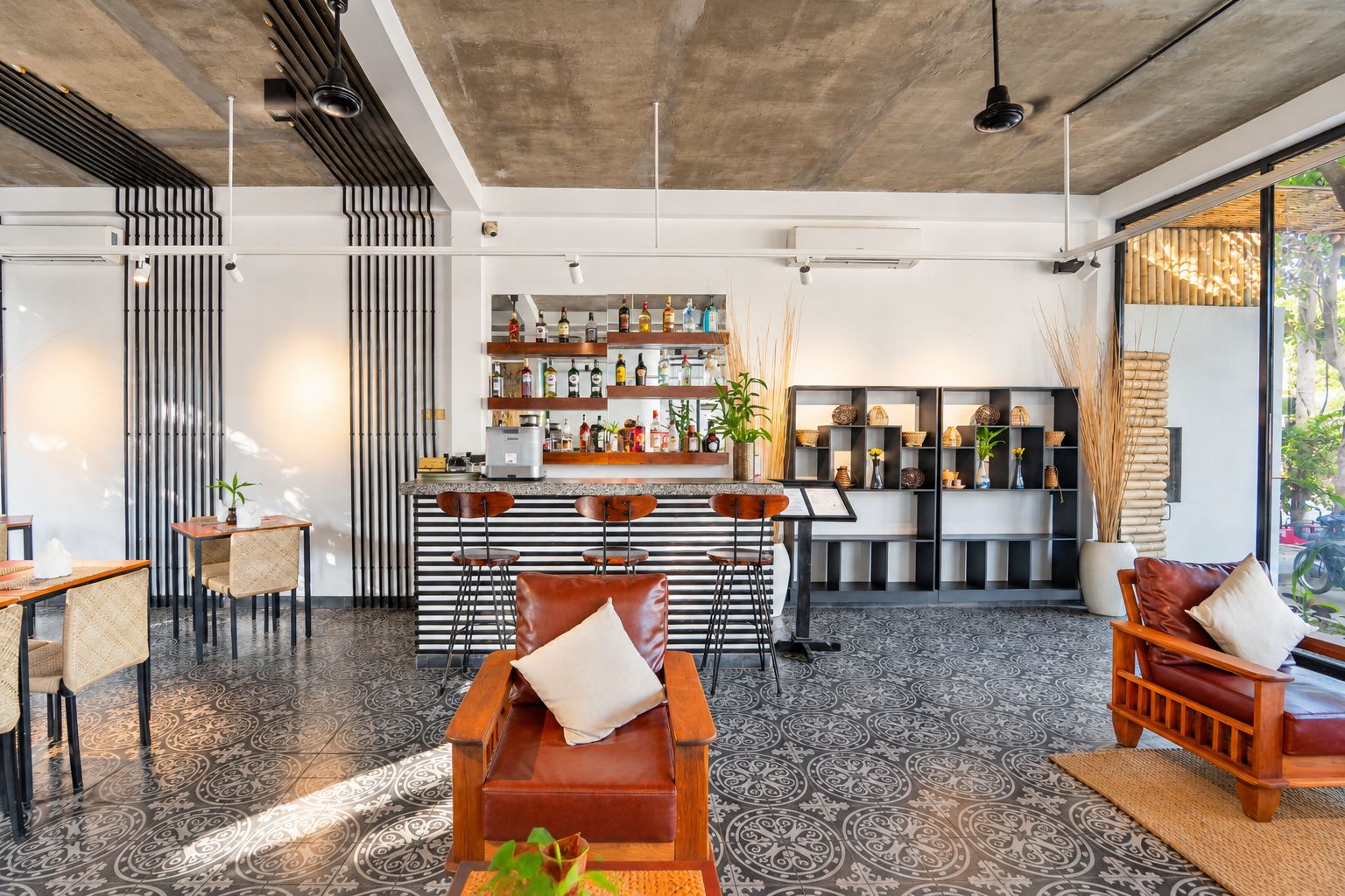 Un interior moderno con una zona de bar, asientos y elementos decorativos.