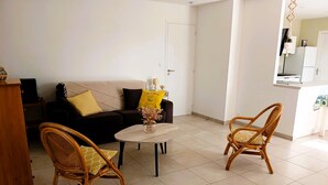 A living room with a sofa, two wicker chairs, a coffee table, and a small decorative vase. - The P'tit Jard near the beach (Jard-sur-Mer)