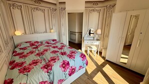 A bedroom with a bed, a dresser, a vanity, and a wardrobe. - Lago Bello Apartament with lake view (Stresa)