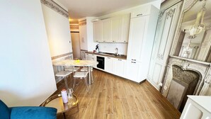 A compact living space with a dining area, kitchenette, and a fireplace. - Lago Bello Apartament with lake view (Stresa)