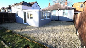 A residential property with a gravel driveway, a small garden area, and a detached garage. - Bungalow - Sleeps 8 - Pets-Enclosed Garden-Parking (Birmingham)