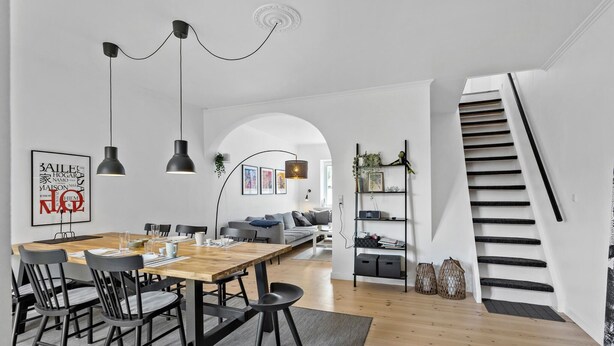 Un intérieur moderne comprenant un coin repas, un escalier et un salon.