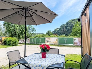 Un espace extérieur aménagé avec une table, des chaises et un grand parasol.