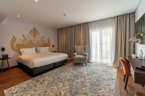 A modern hotel room with a large bed, a desk, a chair, and a view of the outdoors. - Palácio Santa Catarina (Angra do Heroismo)