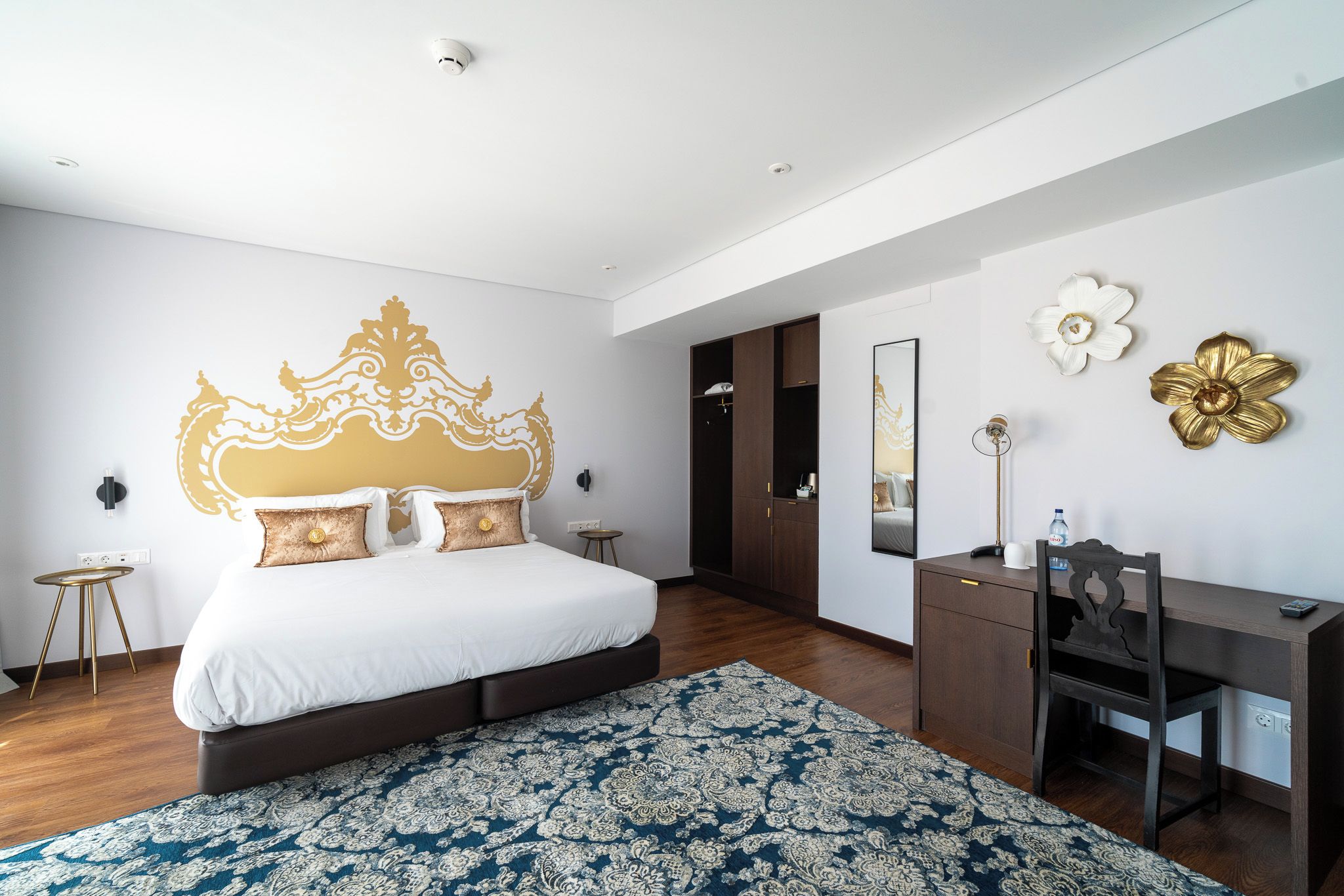 Een moderne slaapkamer met een groot bed, een bureau en een kledingkast.