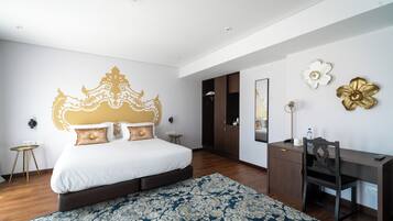 Een moderne slaapkamer met een groot bed, een bureau en een kledingkast.