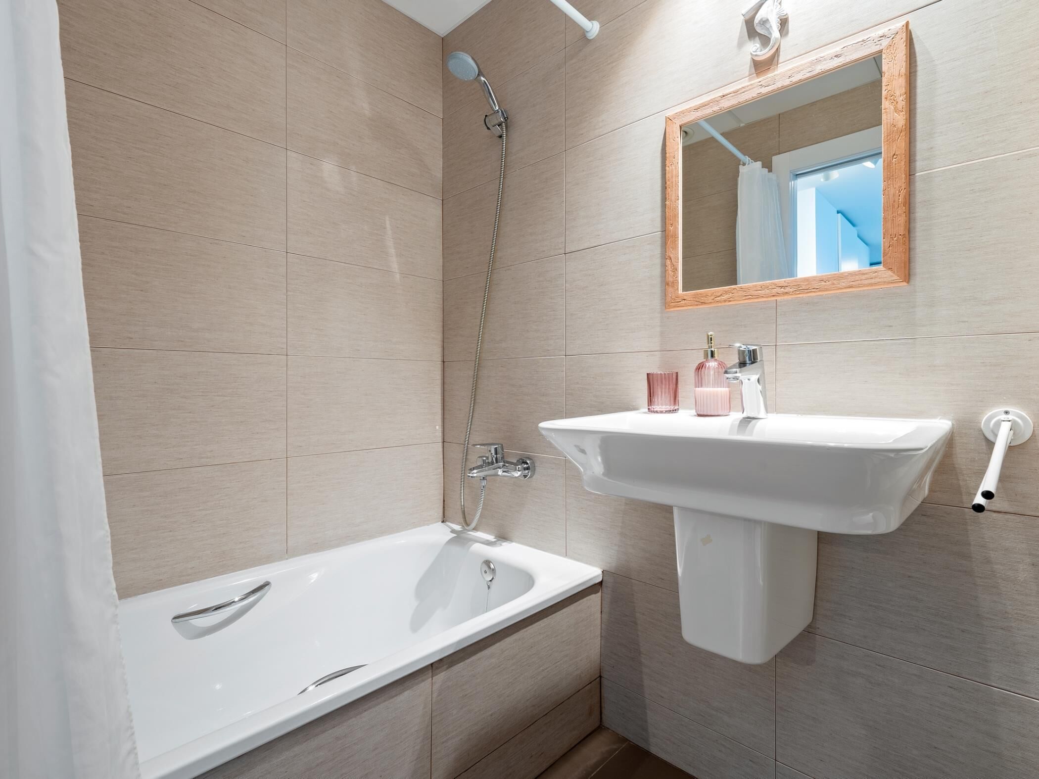 Un baño moderno con bañera, lavamanos y ducha.