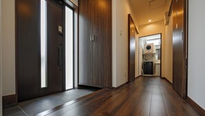 A hallway with wooden flooring and dark wooden doors.