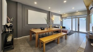 A modern dining area with a wooden table, benches, and a decorative globe. - Nice Decorated townhouse in local neighborhood, 10 minutes walk to BTS (Thunburi)
