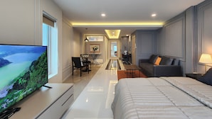 A modern hotel room with a large bed, a TV, a desk, and a sofa. - Nice Decorated townhouse in local neighborhood, 10 minutes walk to BTS (Thunburi)