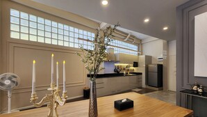 A modern kitchen with a wooden dining table, a vase with flowers, and three lit candles. - Nice Decorated townhouse in local neighborhood, 10 minutes walk to BTS (Thunburi)