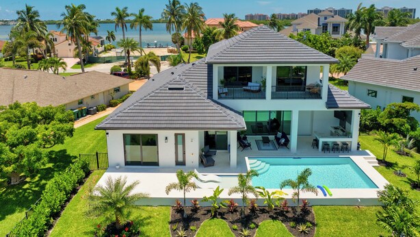 A two-story house with a swimming pool, surrounded by palm trees and a view of the ocean. - Amazing apartment with AC in Bacolod (Bacolod)
