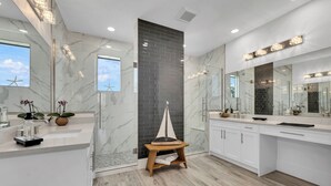 A modern bathroom with a large mirror, a wooden stool, and a ship decoration. - Amazing apartment with AC in Bacolod (Bacolod)