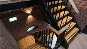 A wooden staircase with black railings leading to a lower level.