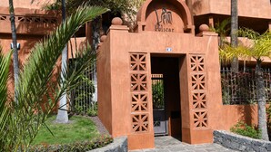 Entrada de un edificio con un letrero que dice 'Pelicar' y una señal 3D encima.