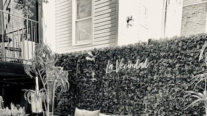 A patio with a sofa, a table, and potted plants.