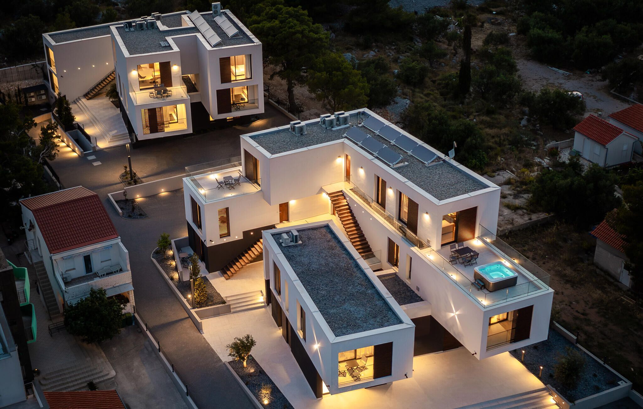 Ein modernes Mehrfamilienhaus mit Dachpool und Solaranlage.