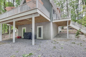 Ein zweistöckiges Haus mit einer überdachten Terrasse und einer Treppe, die zum oberen Stock führt.