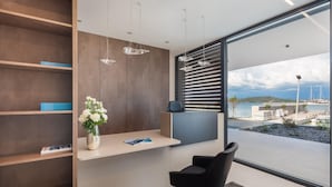 A modern office with a desk, chair, and shelves. It has a view of a marina with boats and a distant island. - Gorgeous apartment in Betina with WiFi (Betina)