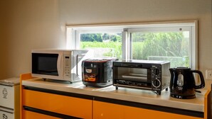 Eine Küche mit Mikrowelle, Toaster und Kaffeemaschine an einem Fensterplatz.