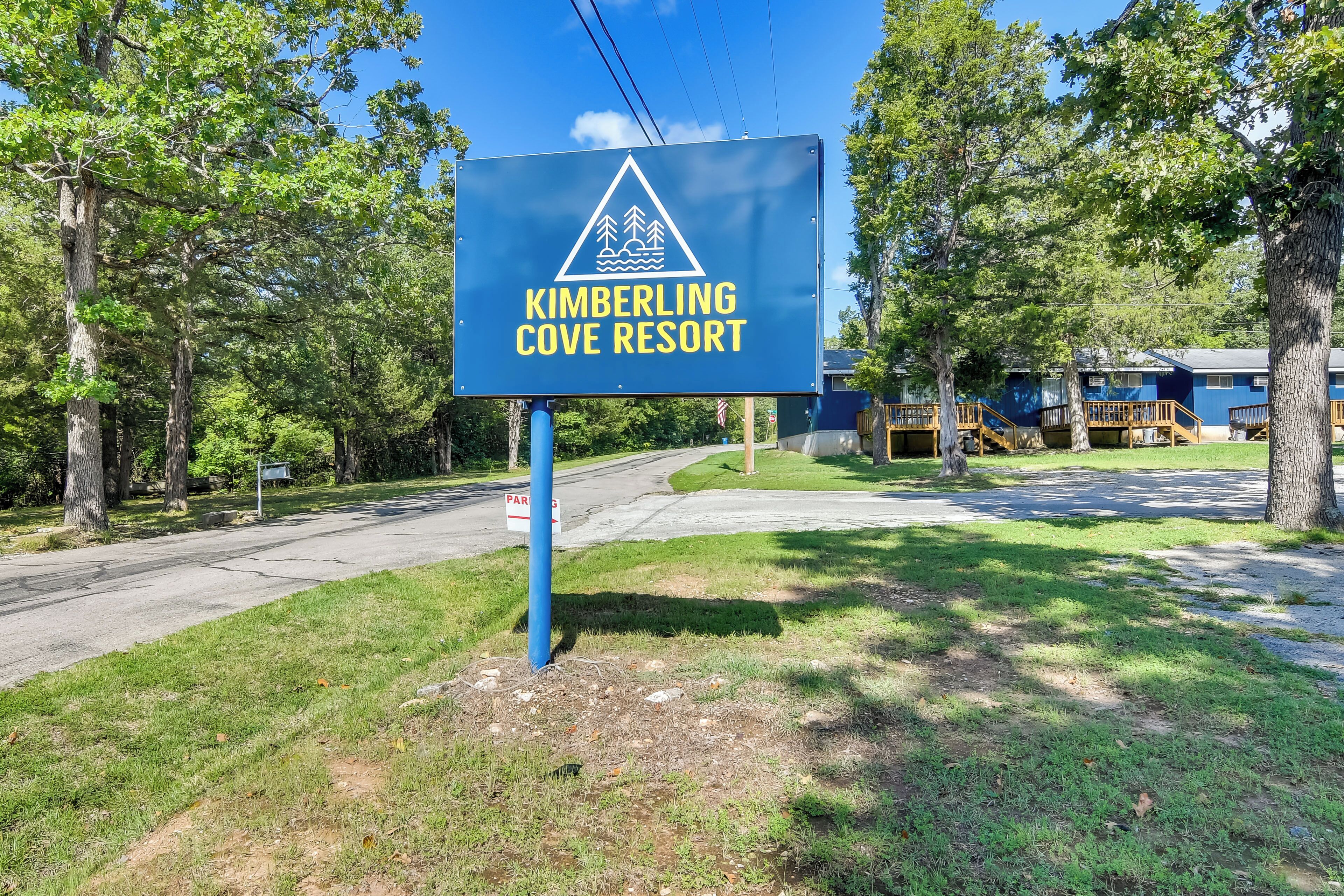 A sign for Kimberling Cove Resort with a triangular logo indicating outdoor activities.