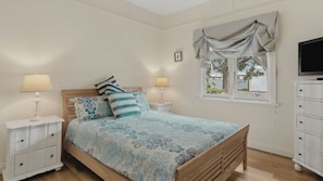 A bedroom with a bed, nightstands, a TV, a window with curtains, and a dresser. - Maison Cottage in Queenscliff (Queenscliff)