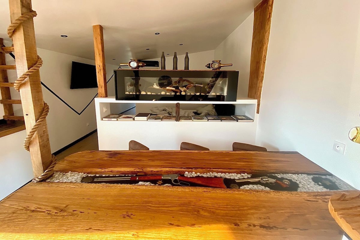 Un tavolo da pranzo in legno con un fucile e munizioni.