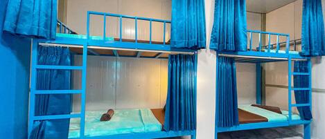 A bunk bed room with blue curtains and a marble floor.