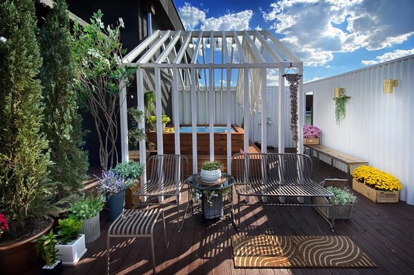 A wooden deck with a white pergola, seating area, and potted plants. - Hotel Voll Seoul (Seoul)