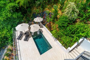 A rooftop pool with a clear view of the surrounding lush greenery and a modern architectural design.