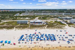 A beach with numerous umbrellas and people.