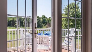 En terrasse med udendørs møbler og udsigt til et pool.