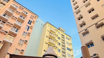 A multi-story residential building with balconies and a clear blue sky.