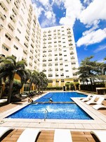 Una piscina al aire libre, camas de piscina gratis, sombrillas