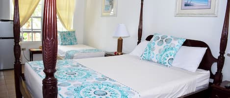 A four-poster bed with a matching canopy, two bedside tables, a nightstand, a wall clock, and a framed picture.