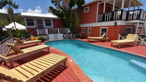 A swimming pool with wooden loungers and a red deck. - The Catamaran Hotel (Falmouth Harbour)