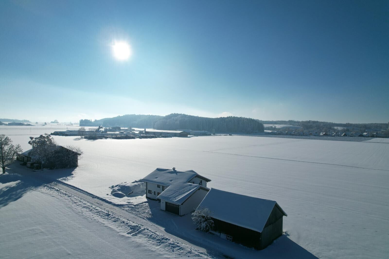 A snow-covered landscape with buildings and a clear sky.