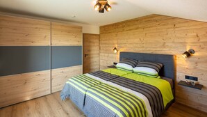 Un dormitorio con cama, paredes de madera y dos luces fijadas a la pared.