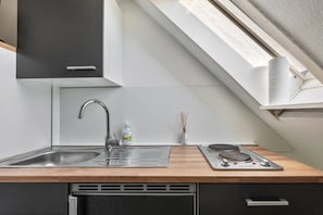 A modern kitchen with a sink, faucet, and stove.
