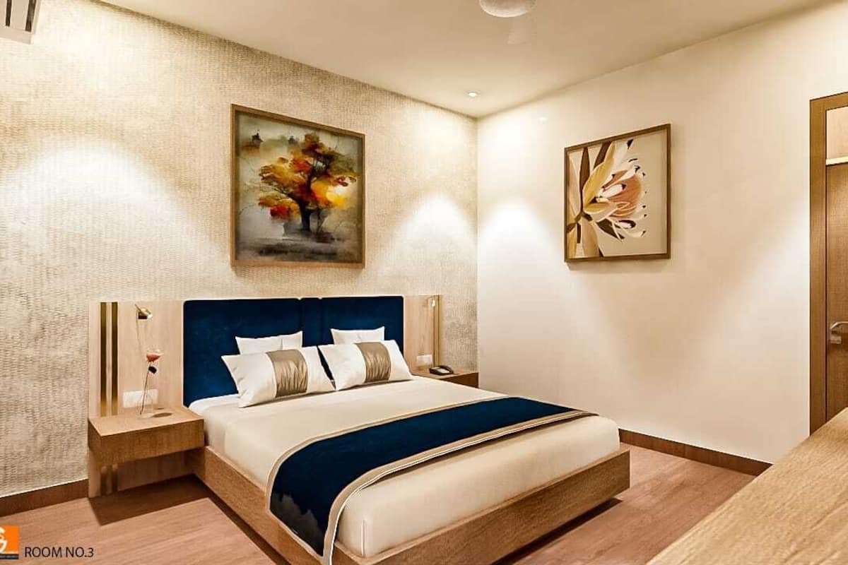 Camera d'albergo moderna con un grande letto, un comodino e due quadri appesi al muro.