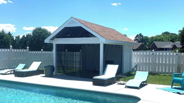 A swimming pool with lounge chairs and a covered patio area.