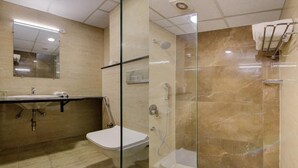 A modern bathroom with a glass-enclosed shower, a toilet, and a sink with a mirror above. - Royal Culture (Greater Noida)