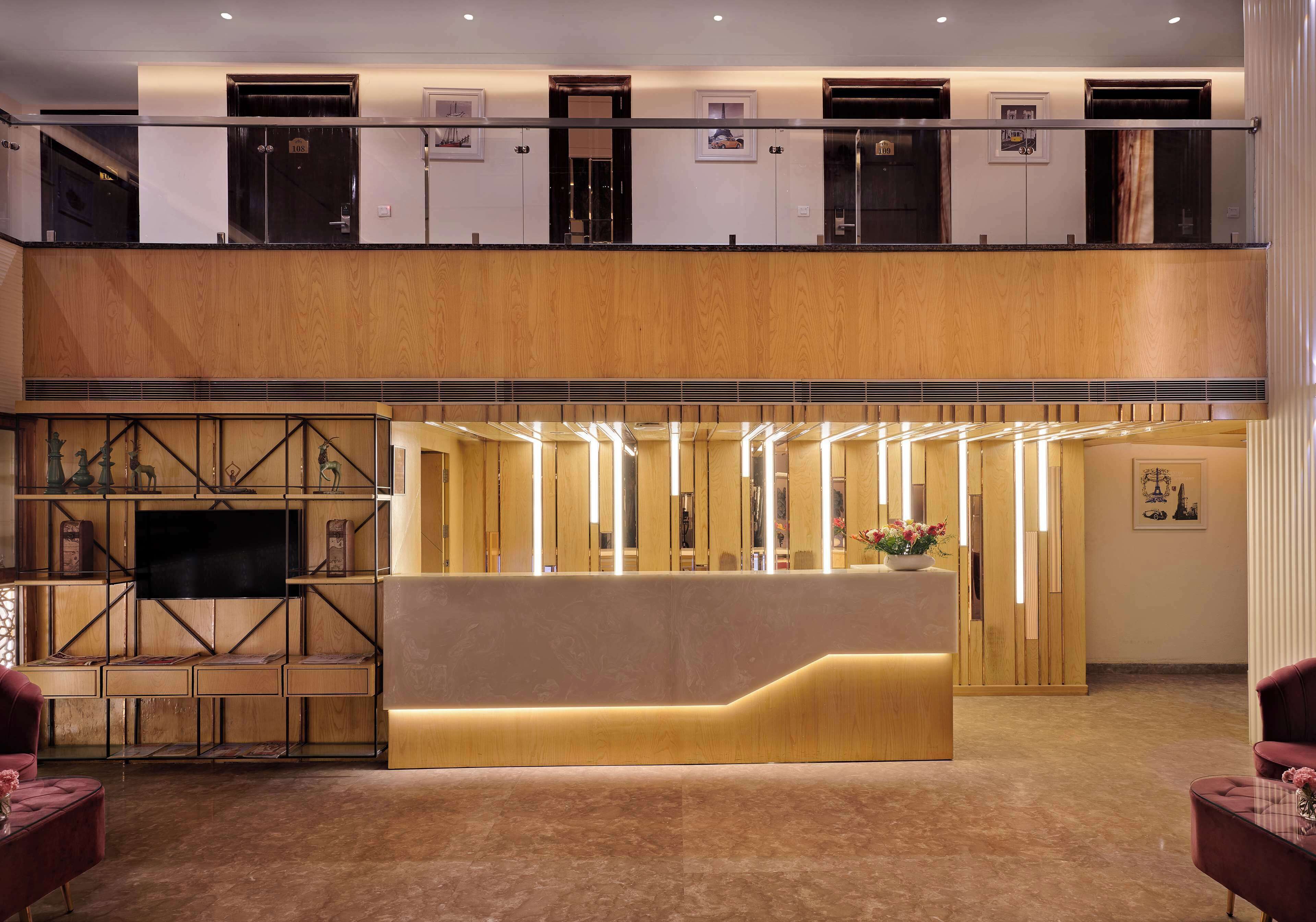 Un vestíbulo de hotel con recepción, televisor y zona de estar.