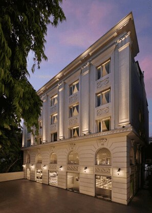 Un immeuble à plusieurs étages de style architectural classique, caractérisé par des fenêtres en arc et des moulures décoratives.