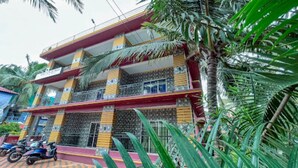 A multi-story building with balconies, a tiled facade, and a parked motorcycle. - ronz vis da praia (Calangute)