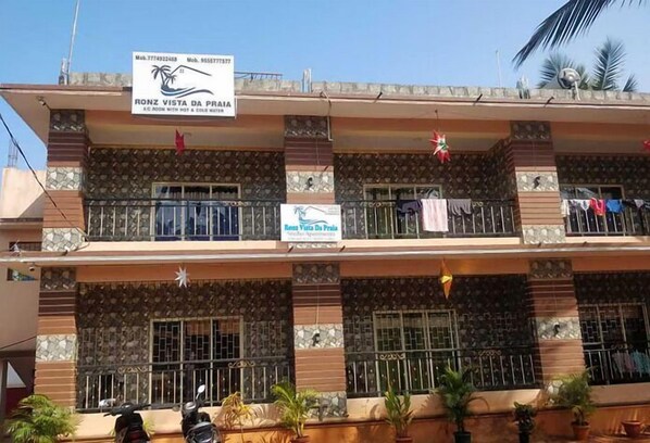A multi-story building with balconies, a signboard advertising "Ronz Vista Da Praia" and "A/C Room with Hot & Cold Water." - ronz vis da praia (Calangute)