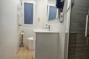 Une petite salle de bain comprenant des toilettes, un lavabo et un miroir.