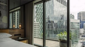 A modern hotel room with a large window, a bed, a bedside table, and a potted plant. - Hyatt Centric City Centre Kuala Lumpur (Kuala Lumpur)