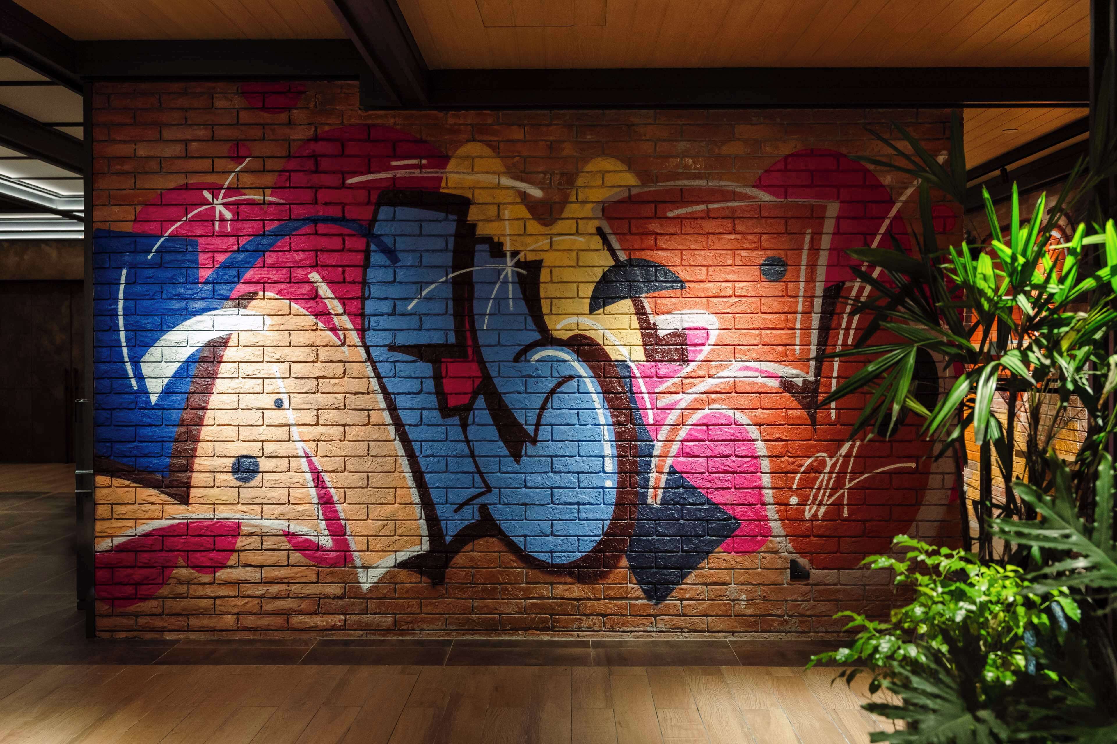 A brick wall with colorful graffiti art.