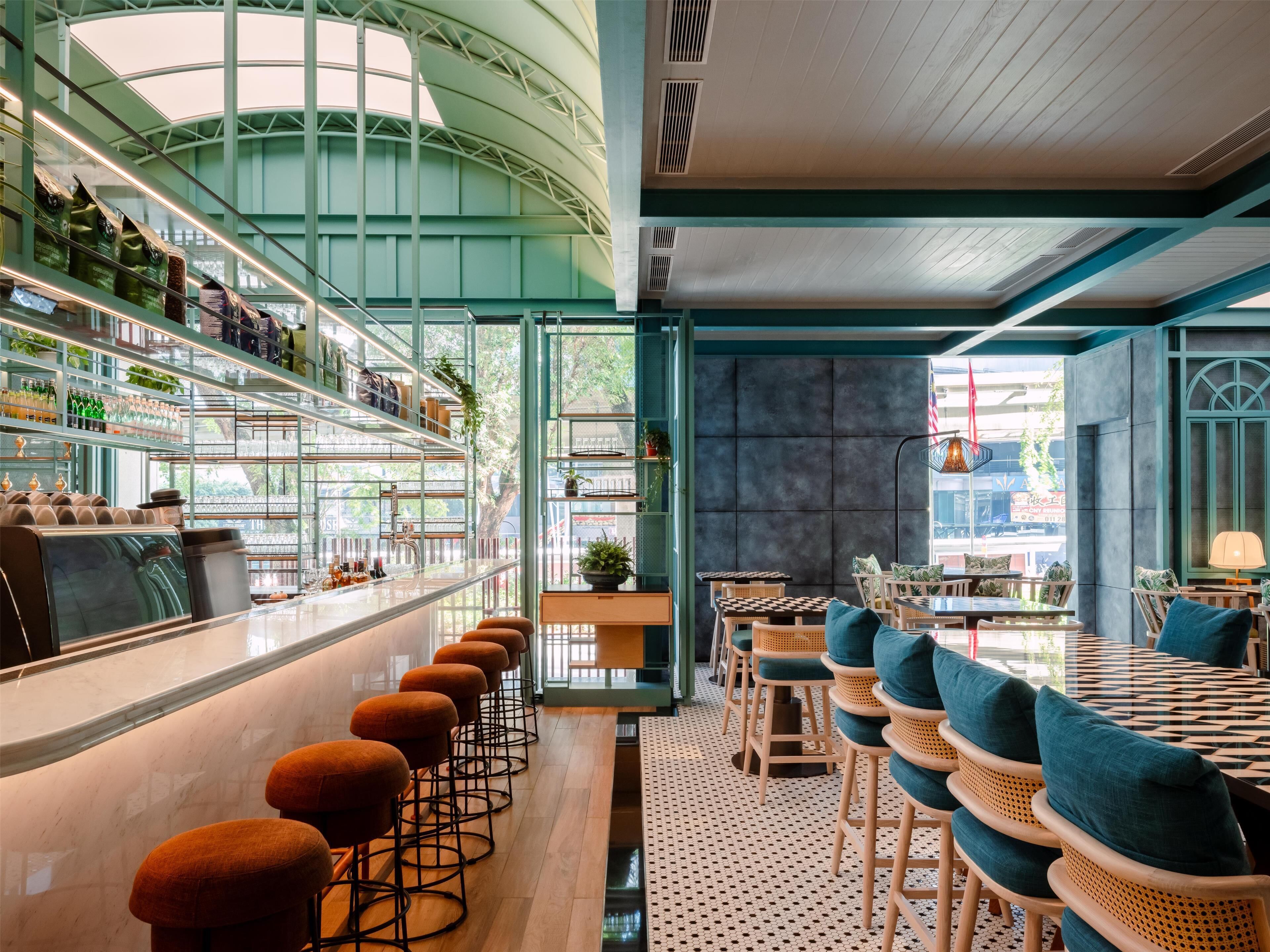 A modern bar area with a long counter, bar stools, and shelves stocked with bottles and glasses.